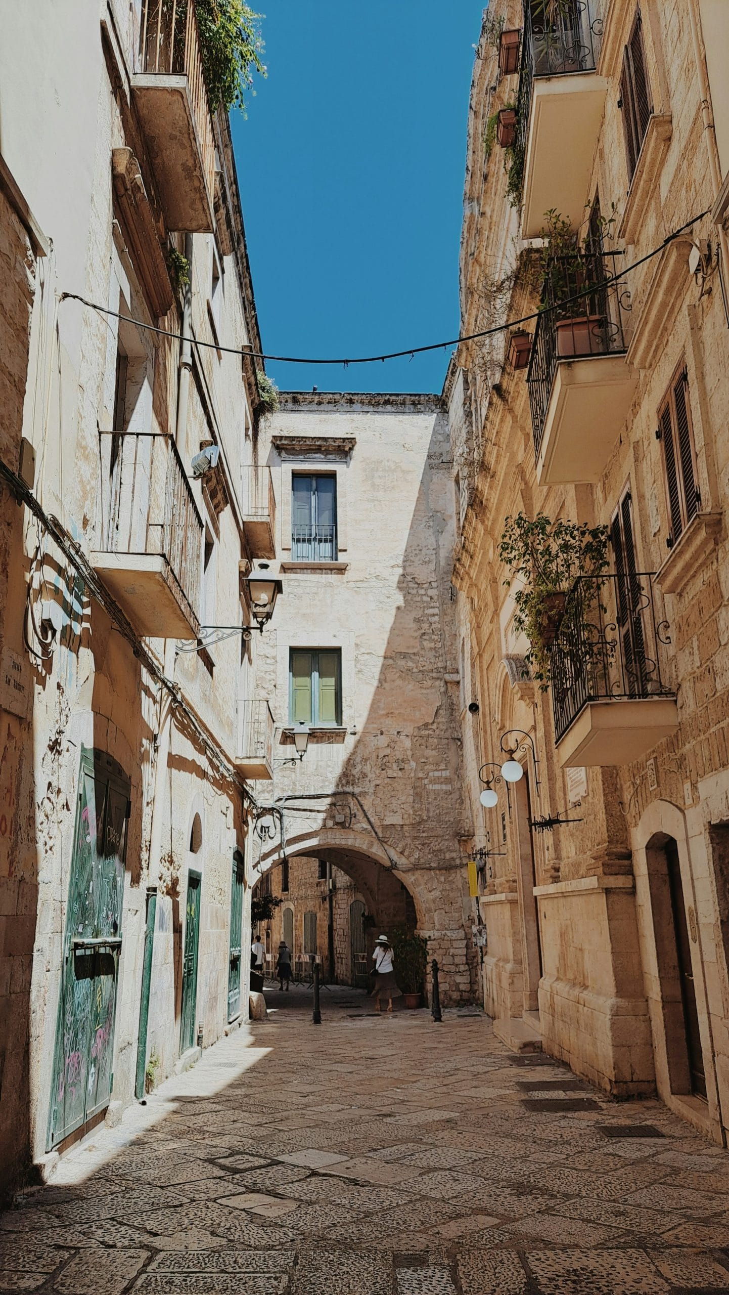 A cobblestone street between two buildings in Bari