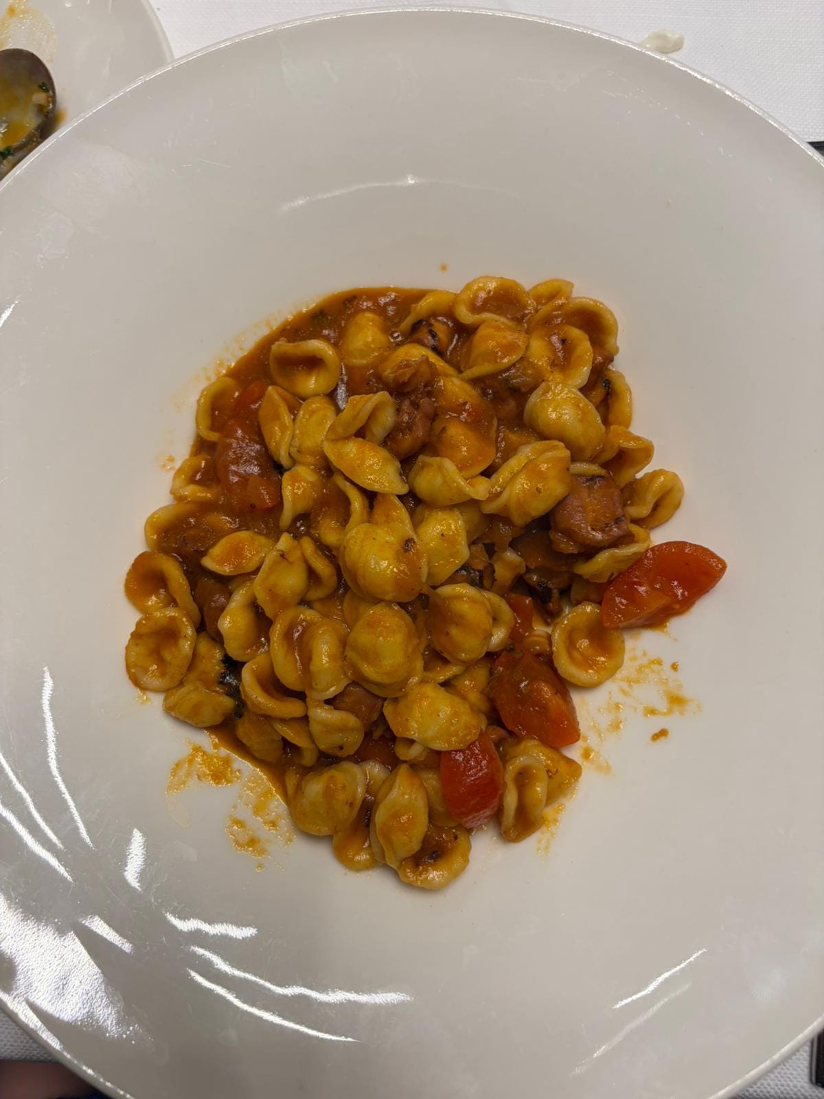 Orecchiette pasta with tomato sauce on a white plate in Bari Vecchia