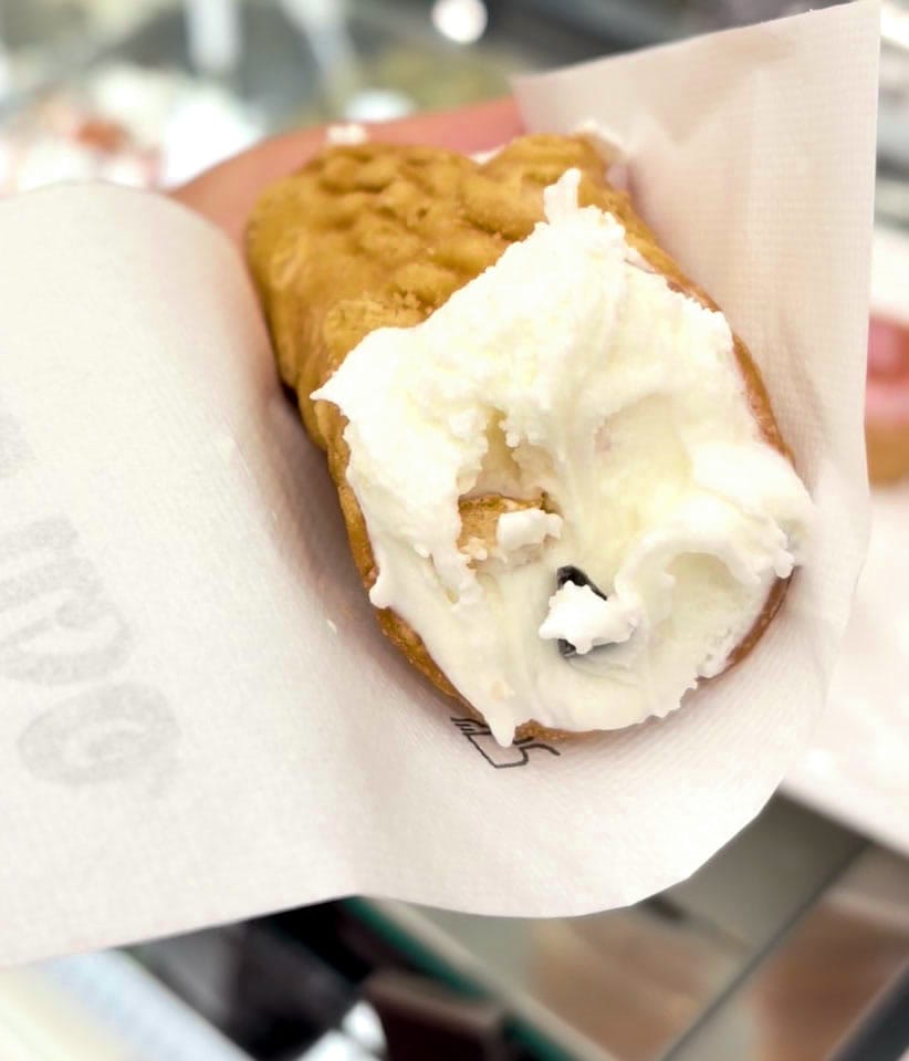 A cone of Caruso fiore di latte gelato handed across the counter
