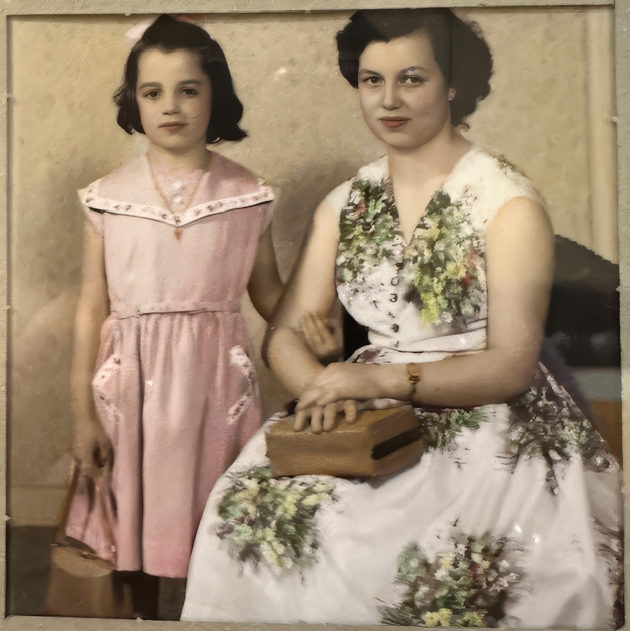 Hand-coloured studio portrait of Franca’s mother Caterina as a young woman, seated in a floral dress with her hand on a book, beside her younger sister Elisa, a girl in a pink dress.