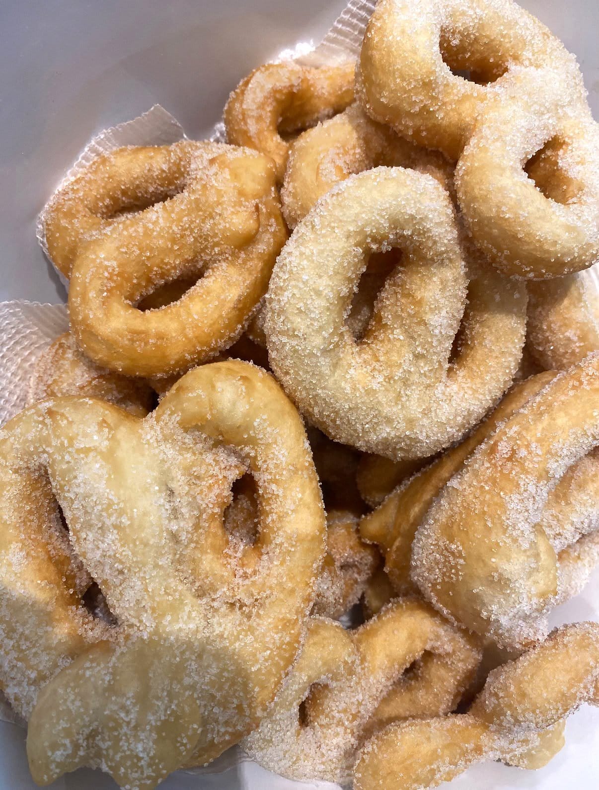 Caterina’s zeppoli: golden, pretzel-shaped fried dough coated in sugar, piled in a bowl.